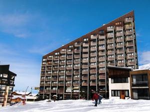 a large building in the snow with people in front of it at Résidence Grande Masse - Appartement pour 5 en bord de piste aux Ménuires MAE-4894 in Les Menuires