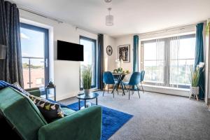 a living room with a green couch and a table at Cozy Flat near Heathrow - Balcony & Free Parking in Colnbrook