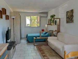 a living room with a couch and a tv at Studio Jasmin in Le Beausset