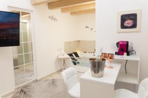 a white room with a table and a mirror at 3 Rooms - Perla private loft with jacuzzi in Catania