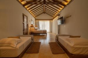 a bedroom with two beds and a television in a room at Villa Tapi in Jericoacoara