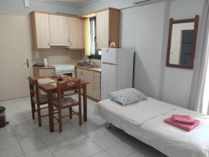 a small kitchen with a table and a table and a bed at Apostolos House in Panagioúda