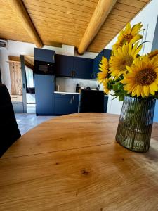 a vase of yellow flowers sitting on a wooden table at Bajkowo Domki in Wola Matiaszowa