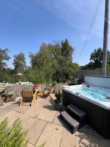 una vasca idromassaggio in un cortile con tavolo e sedie di Treetops Cottage at Treetops Hideouts a Richmond