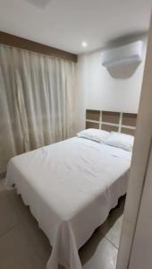 una camera da letto con un grande letto bianco con lenzuola bianche di Porto de Galinhas - Aline Duque Residence, Flat 205 a Porto De Galinhas