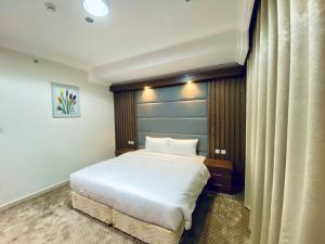 a bedroom with a large white bed in a room at Itlalat Uhud Hotel - فندق إطلالة احد in Medina +23 photos