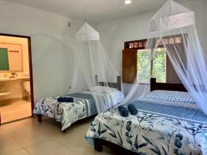 a bedroom with two beds and a window at Casa Majanicho - Naturaleza - Mar - Parrilla - AC in Rincón