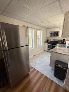 a large kitchen with a stainless steel refrigerator at The Cozy Back Bungalow in Warwick