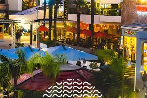 a group of tables and umbrellas in a city at night at Exclusive and Secure Apartment Parque Arauco Las Condes in Santiago