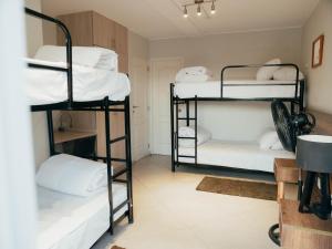 a room with three bunk beds with white pillows at The Point Miraflores, Lima in Lima