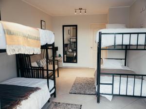 a room with three bunk beds and a hallway at The Point Miraflores, Lima in Lima