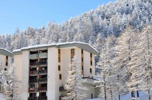モンジェネヴルにあるRésidence Les Miandettes - Grand appartement aux pieds des pistes MAE-8444の山の前に雪に覆われた木々がある建物 +8枚の写真