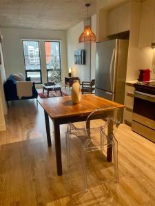 モントリオールにあるCozy apartment-Old Port Montrealの木製のテーブルと椅子のあるキッチンとリビングルーム