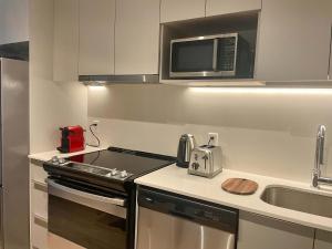 モントリオールにあるCozy apartment-Old Port Montrealのコンロと電子レンジ付きのキッチン