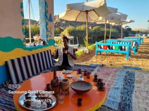 a man sitting at a table in front of a table with at Cataract Nile View Rooms in Shellal