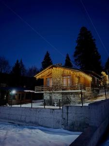 a house is lit up in the snow at night at Villa Fox Bakuriani in Bakuriani