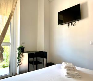 a bedroom with a bed with a television on the wall at New Residence Emilia in San Donato Milanese