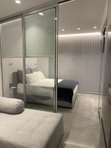 a bedroom with two beds and a glass wall at SeaNest Bali in Bali
