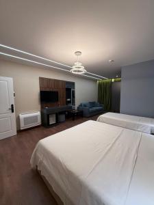 a bedroom with two beds and a living room at Hotel Muja in Rinas