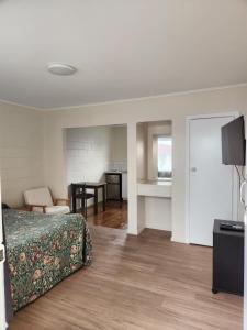 a bedroom with a bed and a living room at Gardena Court Motel in Hamilton