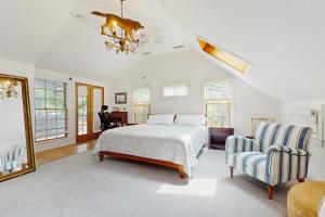 un dormitorio con una cama y una silla en Great White Cape Escape, en Orleans