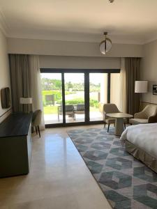 een hotelkamer met een bed en een woonkamer bij Apartment at Adress Golf in El Alamein