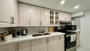 une cuisine avec des armoires blanches et un évier dans l'établissement Spacious and Luxurious 2BR Suite with Huge Windows, à Mississauga