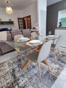 a dining room with a glass table and chairs at Apartamento Brisa in Viana do Castelo