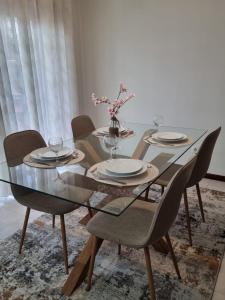 a dining room table with chairs and a glass table top at Apartamento Brisa in Viana do Castelo +6 photos