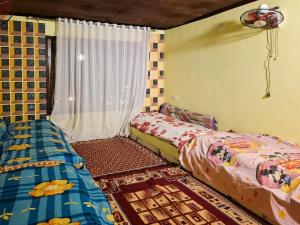 a bedroom with two beds and a window at Nubian Home by Sara in Nag` el-Ramla