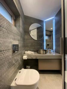 a bathroom with a toilet and a sink and a mirror at SeaNest Bali in Bali
