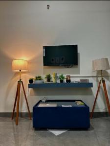 a living room with a tv and two lamps at Your Home in Indore