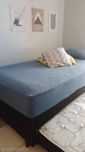 a bed with a blue mattress sitting in a room at Quarto, sala piscina aquecida in Brasilia