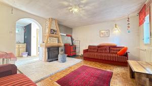 a living room with a red couch and a fireplace at Blueberry Mountain House in Žabljak