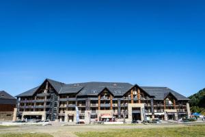 a large building with a black roof at Résidence Serias - T3/6pers SERIAS 22- Peyresourde MAE-3534 in Germ +14 photos