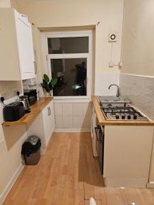 a small kitchen with a stove and a window at Entire 2 Bedroom Apartment City Centre & Stadium in Cardiff