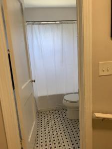 a bathroom with a toilet and a white shower curtain at Home Away from Home Stay - 2 Bedroom,1 Bathroom - Near Capitol Hill in Washington +10 photos