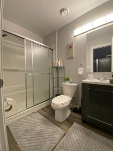 Un baño con ducha, inodoro y lavabo. en Greensville Suites, en Regina 149 fotos más