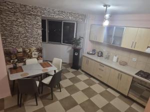 a kitchen with a table and a table and chairs at Apartament Matei in Timişoara