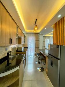 a kitchen with wooden cabinets and a stainless steel refrigerator at luxury 3 bedroom town view apartment with a pool in Kampala +1 photo