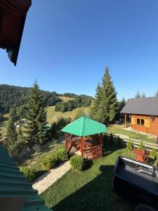 a house with a green umbrella in the grass at Vikendica Davidović in Berane