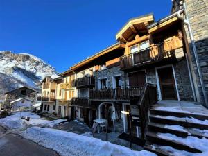 a building in the mountains with snow on the ground at Chalet Aster - Maison de village rénovée sur 3 niveaux 4 pièces pour 6 personnes à St Marcel MAE-6444 in Saint-Marcel