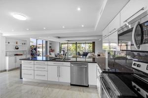 cocina grande con armarios y electrodomésticos blancos en Waterfront Luxe Condo - Close to beach, en Hallandale Beach
