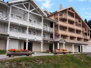 a large building with flowers in front of it at Résidence Chateaux De Crans - Studio lumineux · Balcon MAE-8264 in Magland