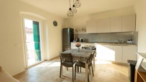 a kitchen with a table and chairs in a kitchen at Le case dei lecci in Riparbella