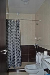 une salle de bain avec toilettes et rideau de douche dans l'établissement Apartments Sunset Paradise, à Makhinjauri 72 autres photos