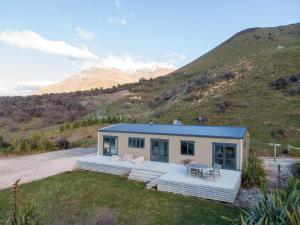een klein huis aan de zijkant van een heuvel bij Alpine Views Farm Stay in Lake Coleridge