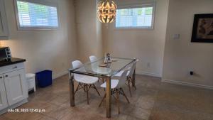 a dining room with a glass table and white chairs at Spacious 2 BR, 3 beds, sleeps 6, kitchen, laundry in Richmond Hill +8 photos
