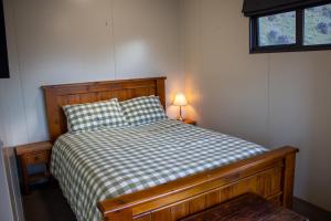 een slaapkamer met een bed met een geruite sprei bij Alpine Views Farm Stay in Lake Coleridge