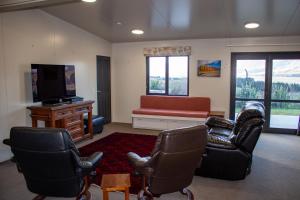 een woonkamer met stoelen en een bank en een tv bij Alpine Views Farm Stay in Lake Coleridge